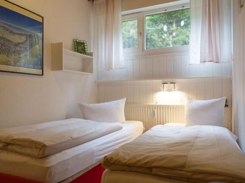 Appartmentvermietung Terrassenpark Schonach في سخوناخ: سريرين في غرفة بها نافذتين
