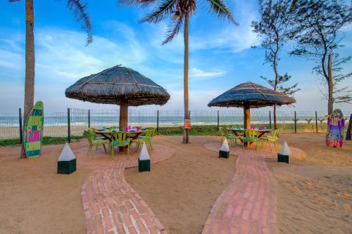 a group of tables and umbrellas on the beach at Radisson Blu Resort Temple Bay Mamallapuram in Mahabalipuram