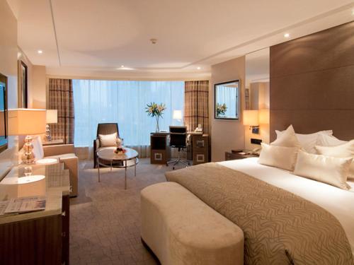 a hotel room with a large bed and a desk at Zhejiang Hotel in Hangzhou
