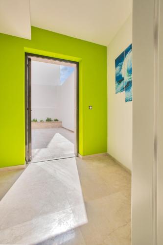 an empty room with a green wall and a door at Magic Stone Apartments in Baška Voda