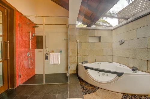 a large bathroom with a tub and a shower at Radisson Blu Resort Temple Bay Mamallapuram in Mahabalipuram