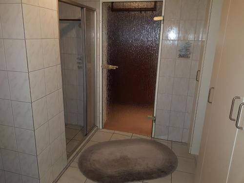 a bathroom with a shower with a rug on the floor at 4 Sterne Souterrain Apartment Alt-Mariendorf in Berlin