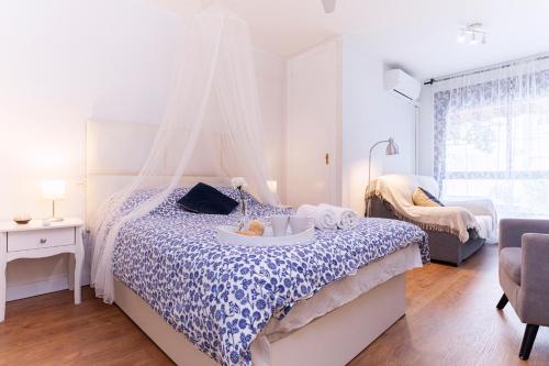 マラガにあるCovadonga Sunny Centerのベッドルーム1室(青と白の掛け布団付きのベッド1台付)