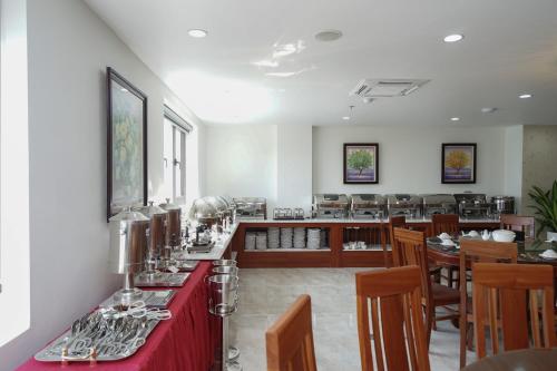 a restaurant with a red counter and wooden tables and chairs at Bảo Hân Hotel in Ha Long
