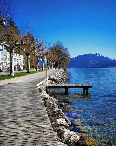 a bench sitting on the side of a body of water at Campanile Annecy Centre - Gare in Annecy