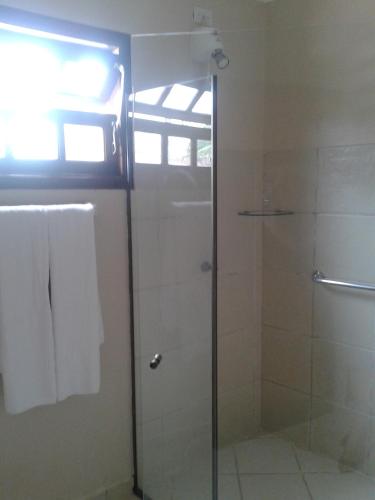a shower with a glass door in a bathroom at Hotel Costa Balena-Piscina Aquecida Coberta in Guarujá