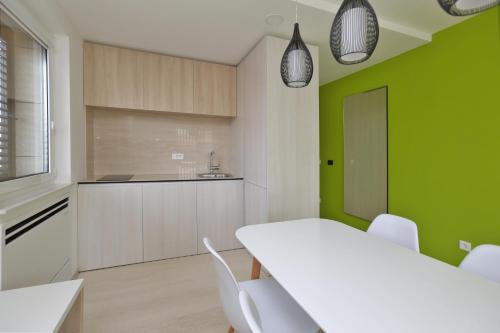 a kitchen with a white table and white chairs at Magic Stone Apartments in Baška Voda