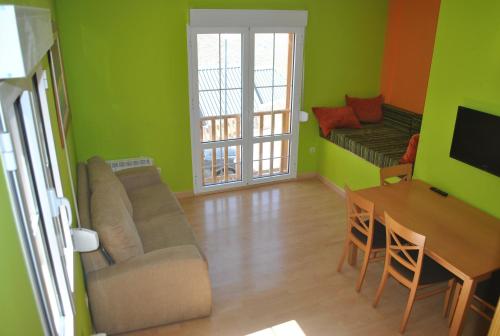 a living room with green walls and a couch and a table at Gran Adosado-Spa en Sierra Nevada hasta14 plazas in Sierra Nevada