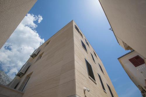 a tall building with the sky in the background at Magic Stone Apartments in Baška Voda