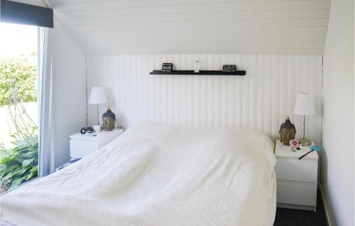 een witte slaapkamer met een wit bed en een raam bij Lovely Home In Storvorde With Kitchen in Egense