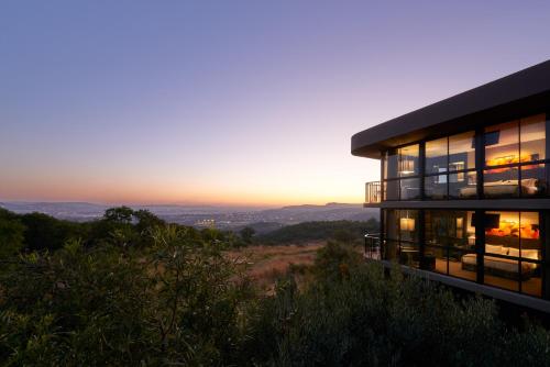 a house on a hill with the sunset in the background at Thaba Eco Hotel in Johannesburg