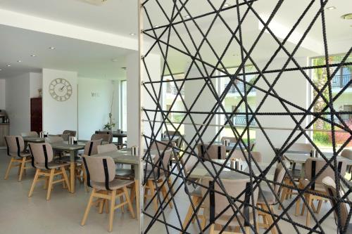 a room with tables and chairs and a clock on the wall at Aristotelis Hotel in Fourka