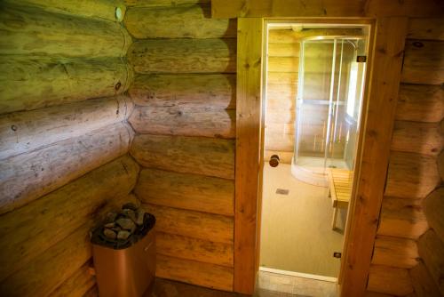 a door in a wooden room with a trash can at Järveveere Puhkekeskus in Valma