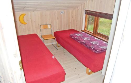 Habitación pequeña con cama roja y silla en Cozy Home In Vordingborg With House A Panoramic View en Næs