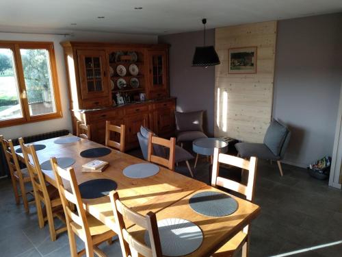 comedor con mesa de madera y sillas en Gîte la Chauve Jotte en Dommartin-lès-Remiremont