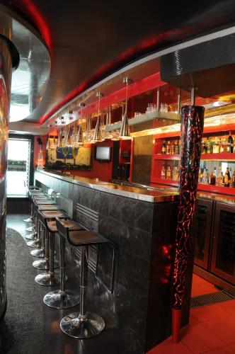 a bar with a row of stools in a restaurant at Lytton Hotel in Kolkata