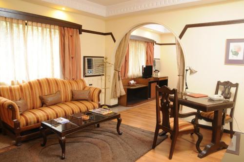 a living room with a couch and a table at Lytton Hotel in Kolkata