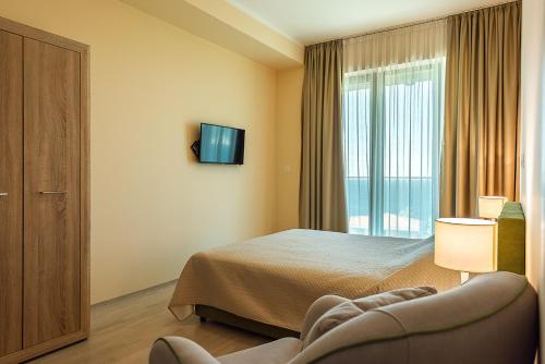 a hotel room with a bed and a tv at Adria Lux Apartments Sveti Stefan in Budva