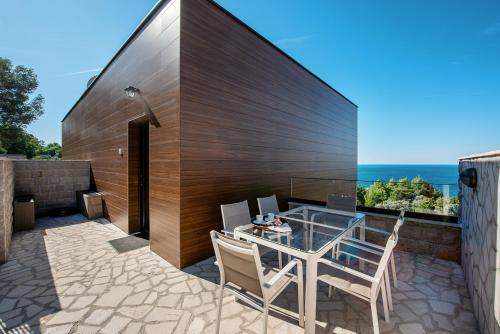 a patio with a table and chairs and the ocean at Adria Lux Apartments Sveti Stefan in Budva