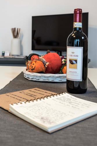 a bottle of wine sitting next to a table with a book at Tosca's House in Palaia