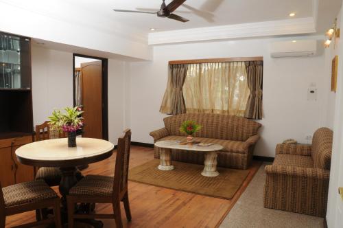 a living room with a couch and a table at Lytton Hotel in Kolkata