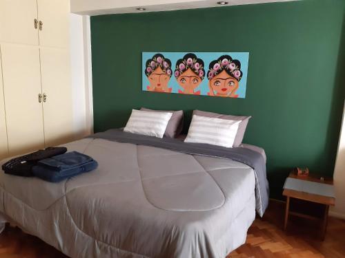 Viva San Martín, Apartamento Luminoso في بوينس آيرس: سرير في غرفة نوم مع جدار أخضر