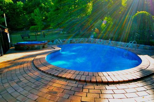 a swimming pool with a brick patio around it at Chestnut Tree Holiday Units in Bright