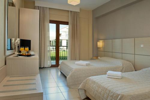 a hotel room with two beds and a television at Aristotelis Hotel in Fourka