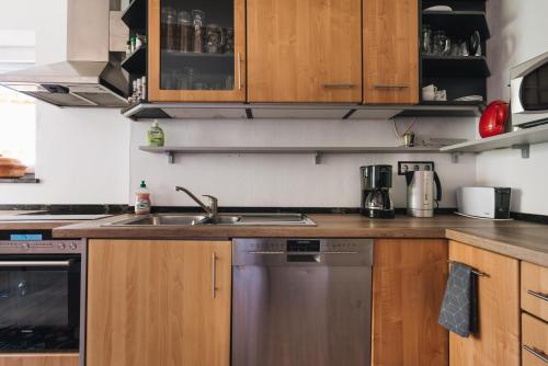 a kitchen with wooden cabinets and a stainless steel dishwasher at Casa Piedro in Starnberg