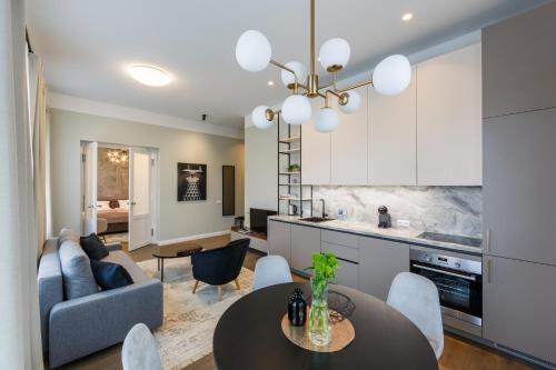 a kitchen and living room with a table and a couch at Laisves ave. Apartments in Kaunas