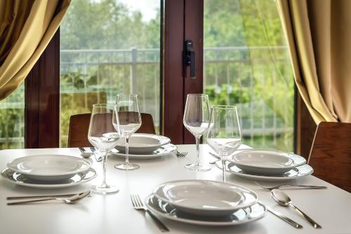 a table with plates and wine glasses on it at Adria Lux Apartments Sveti Stefan in Budva