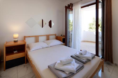 a bedroom with a bed with towels on it at City Pool Apartments Novalja in Novalja