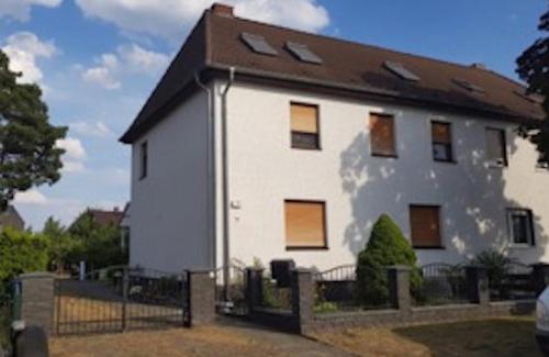 una casa blanca con techo negro en Schorfheider Ferienwohnung, en Eberswalde-Finow