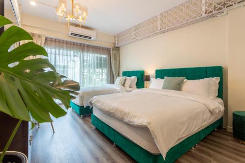 a bedroom with two beds and a large window at Harmony Silom in Bangkok