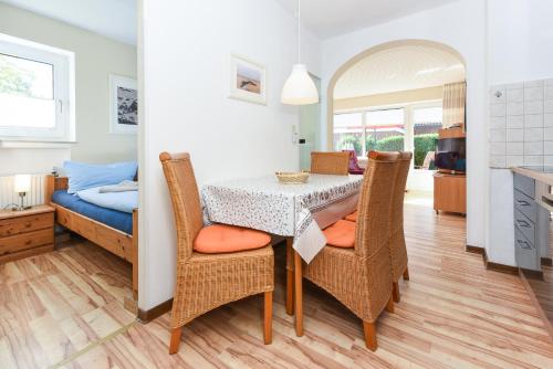 a dining room with a table and chairs and a bed at Haus Stoertebeker in Neuharlingersiel