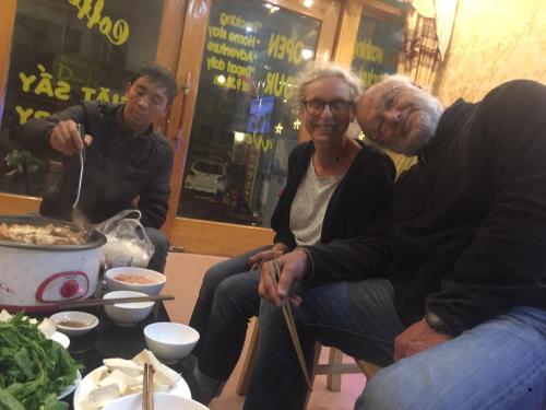 a group of people sitting around a table with food at Viet Duc Guest House in Sa Pa