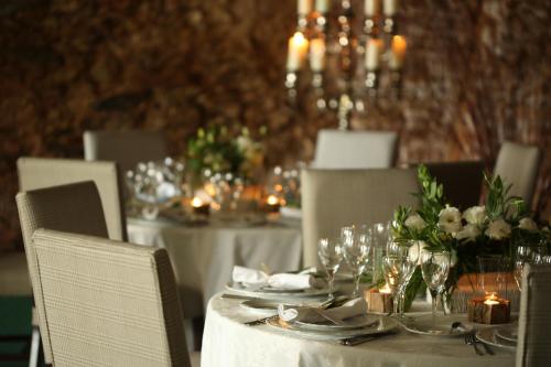 a table with white tables and chairs with candles at Pateo dos Solares Charm Hotel in Estremoz