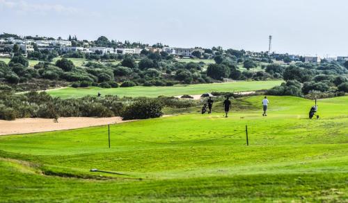 a group of people playing golf on a golf course at Royal Suite Caesarea in Caesarea