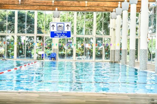 a swimming pool with a sign in front of it at Royal Suite Caesarea in Caesarea