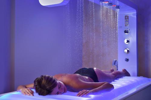 a woman laying on a bed in a hot tub at Borgobrufa Spa Resort Adults Only in Brufa