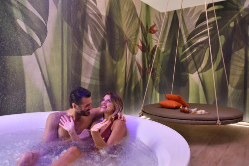 a man and a woman sitting in a bathtub at Borgobrufa Spa Resort Adults Only in Brufa