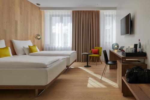 een hotelkamer met 2 bedden en een bureau bij Hotel Passage in Brno