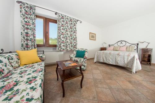 a living room with a couch and a bed at Cascina Dani in Agliano Terme