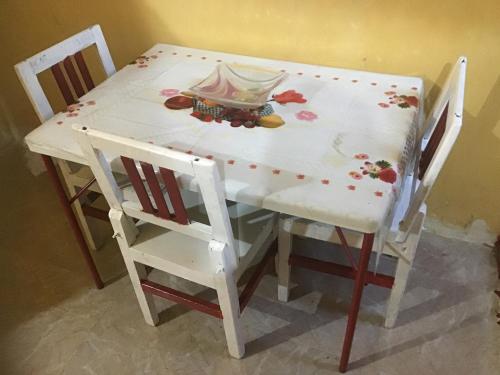 d'une table avec deux chaises et d'une table blanche avec des fleurs. dans l'établissement Otasho Nile view house, à Assouan