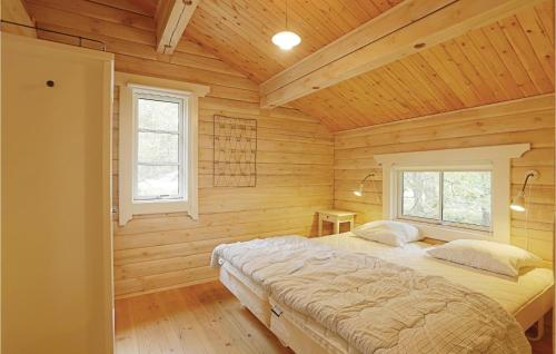 een slaapkamer met houten wanden en een bed in een kamer bij 3 Bedroom Cozy Home In Aakirkeby in Åkirkeby