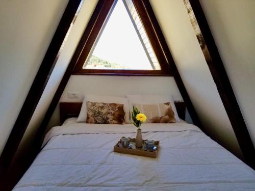 a bedroom with a bed with a window at Eco Village Pavlovic in Žabljak