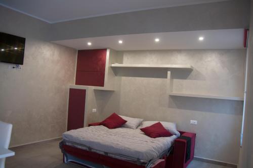 a bedroom with a bed with red pillows and shelves at NF8 Torino in Turin