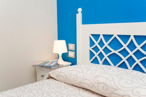 a bedroom with a bed with a blue wall at Hotel Residence Il Porto in Mattinata