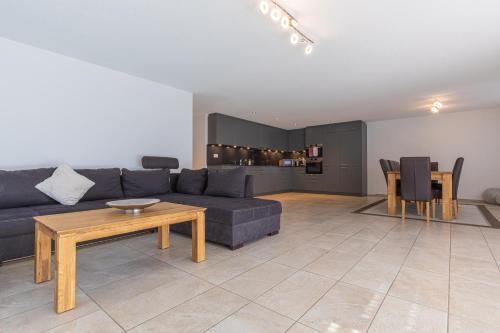 a living room with a couch and a table at Schilthorn Apartment - Aare Jungfrau AG in Wilderswil