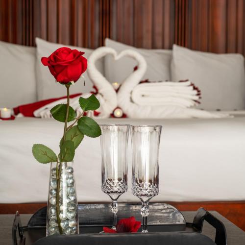 a table with a rose in a vase and two glasses at Villa 1565 - Saint Augustine in Saint Augustine